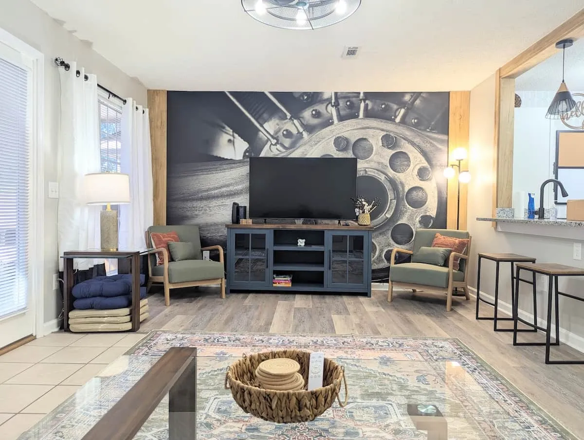 Blue Brick furnished rental living room with custom aviation-inspired mural and comfortable seating